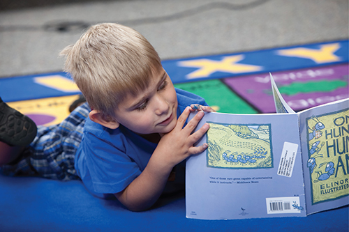 a little boy reading a book